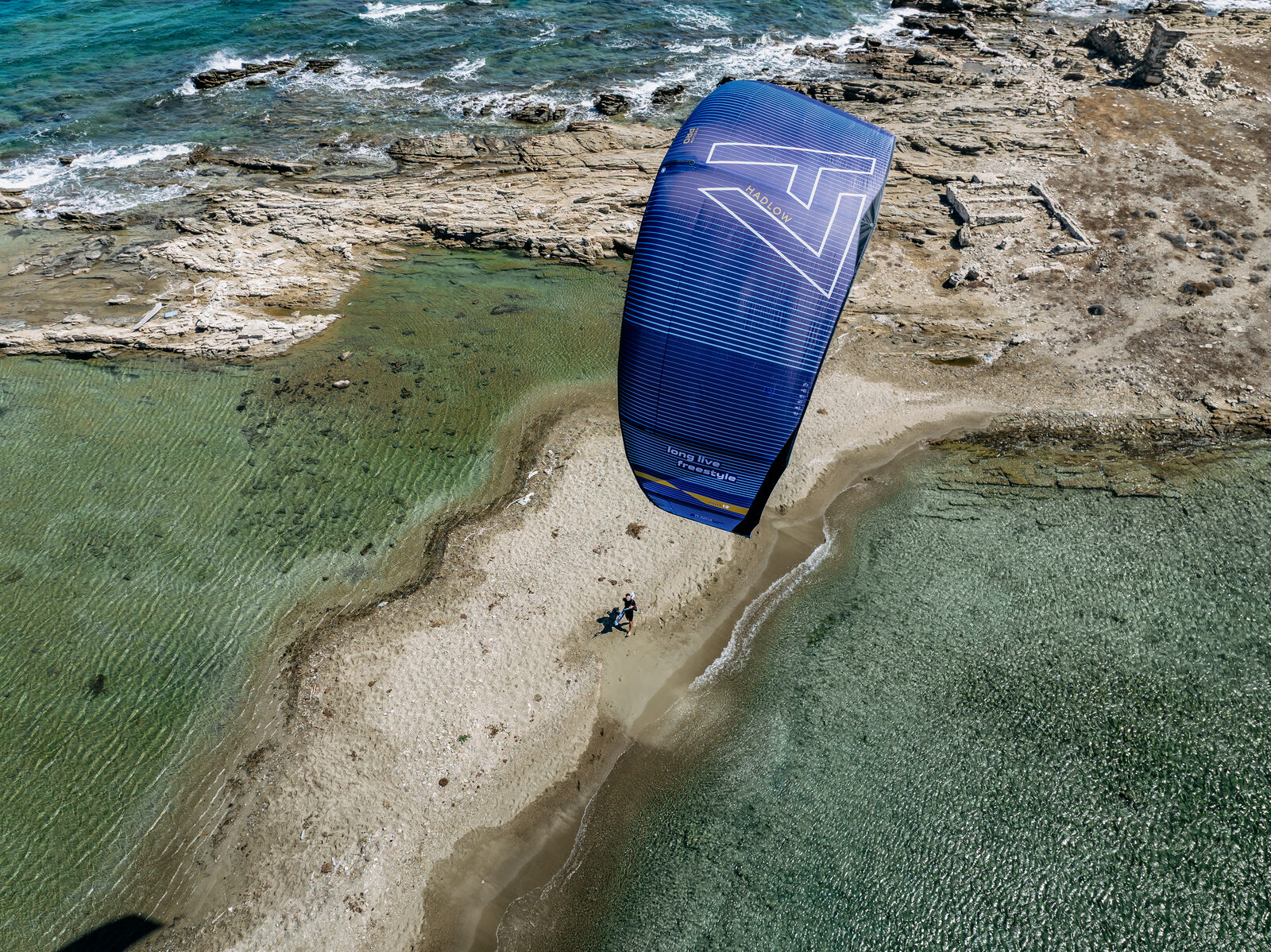 Drone shot of Aaron Hadlow kiteboarding over a lagoon